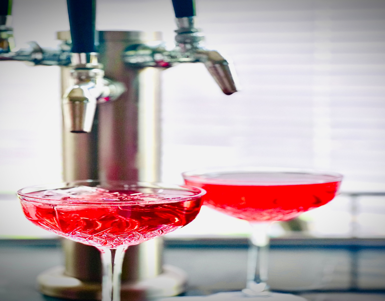 Two delicious 'Muse' blends being poured from a tap into crystal glasses.